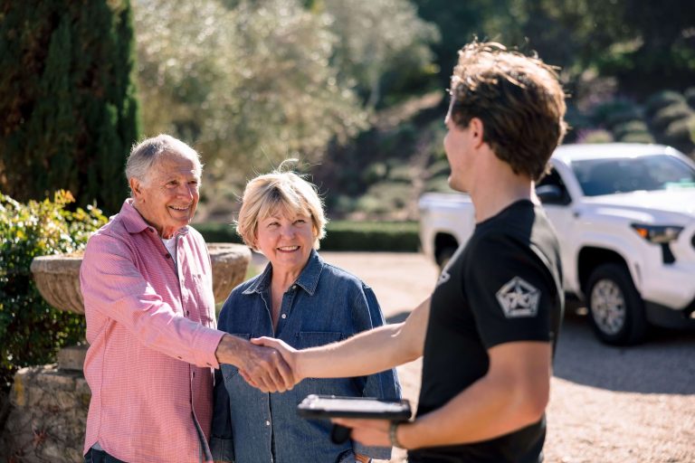 Meathead mover shaking hands with a smiling older couple