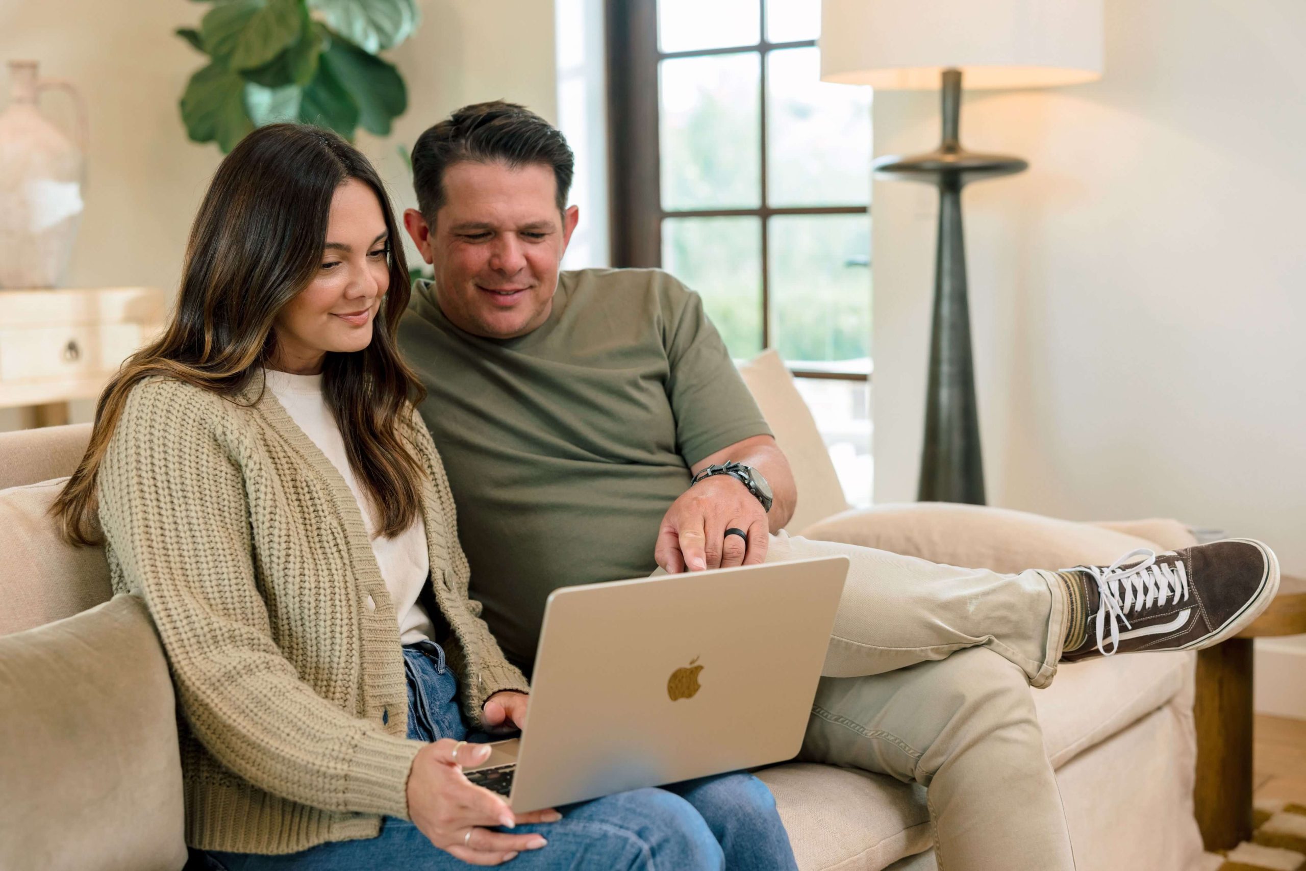Couple on a couch planning their move on a laptop