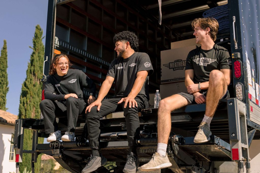 Meathead movers relaxing on the back of a moving truck