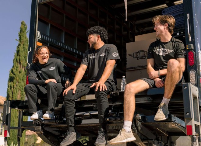 Meathead movers relaxing on the back of a moving truck