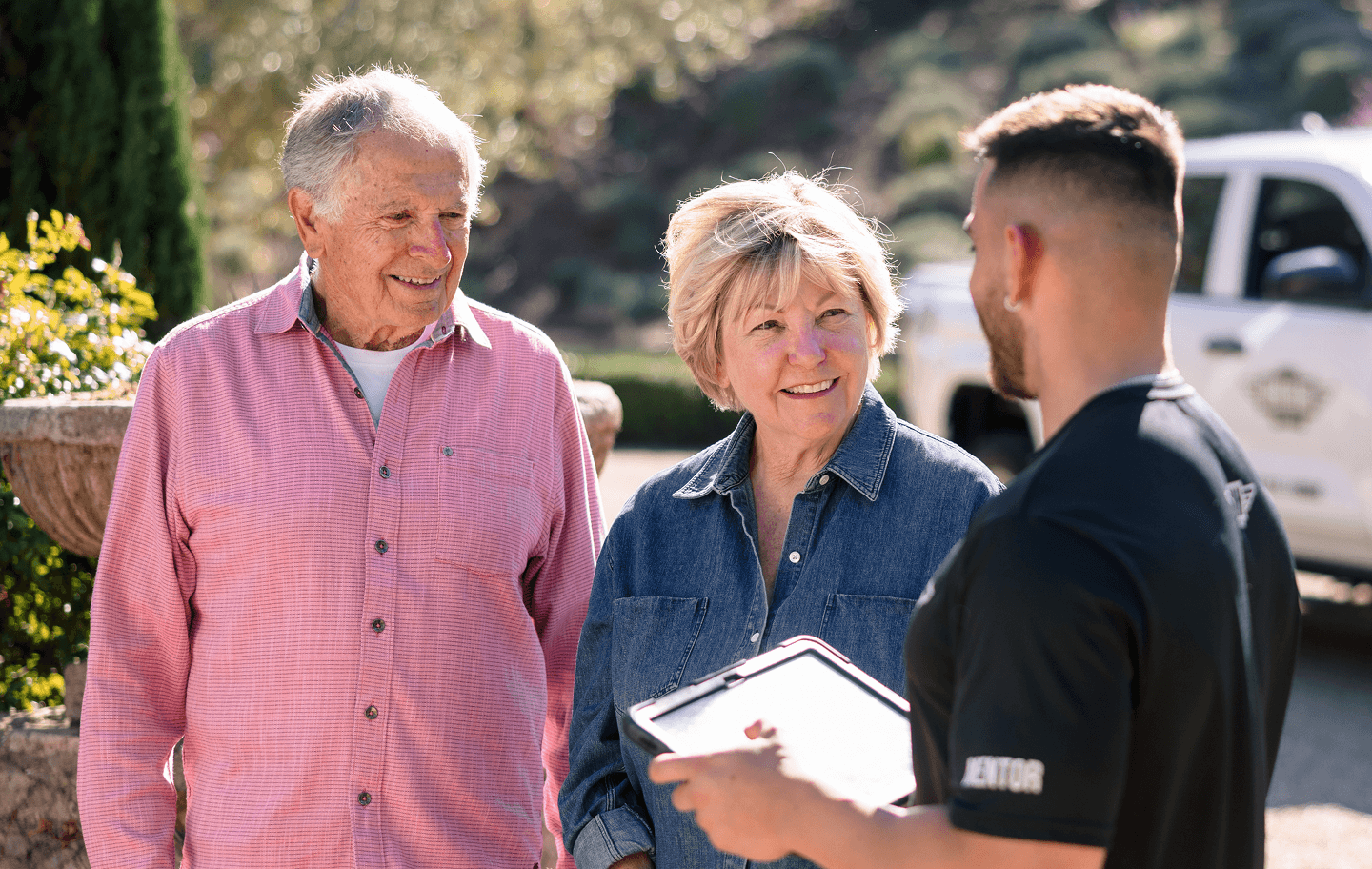 Meathead mover reviewing moving details on a tablet with an older couple