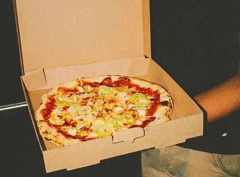 Fresh pizza in an open pizza box