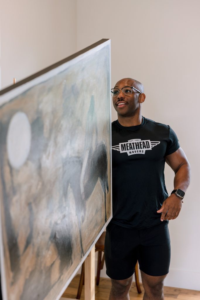 Meathead mover carrying a large framed painting