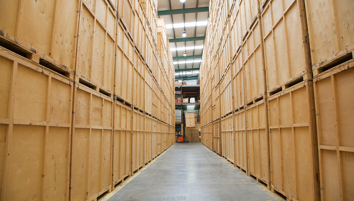 Rows of stacked wooden storage vaults in a warehouse