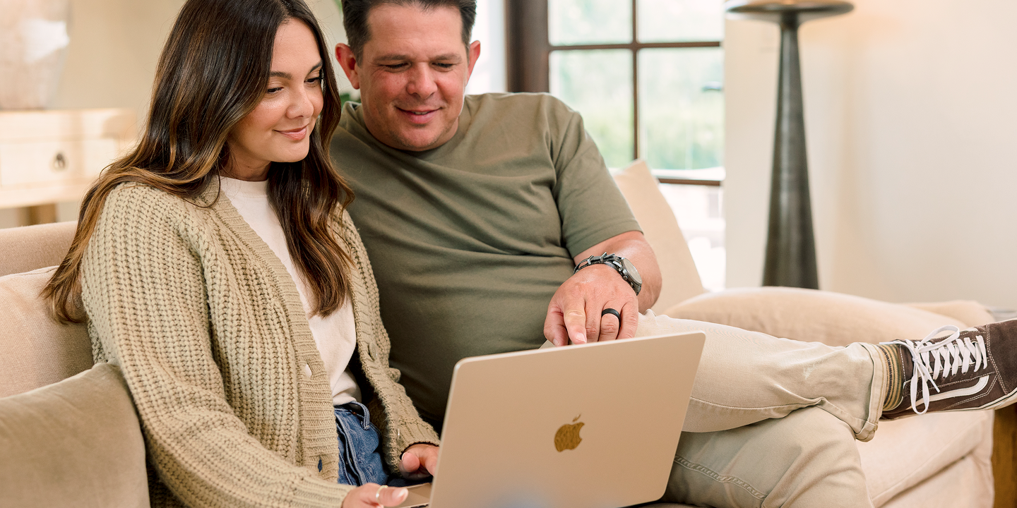 Couple on a couch planning their move on a laptop