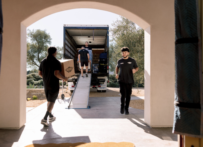 Meathead movers loading boxes up a ramp into a moving truck