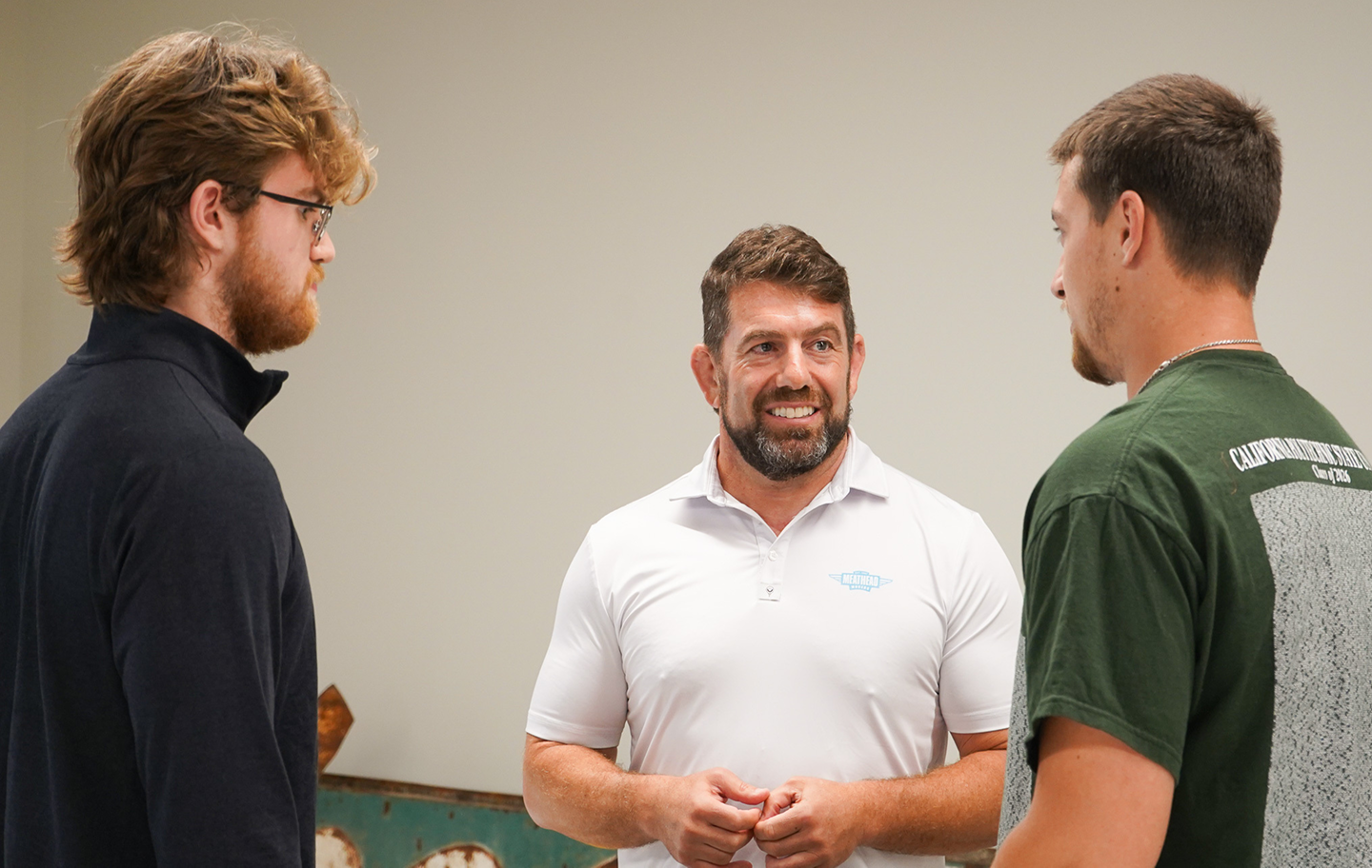 Meathead Movers leader talking with two young men